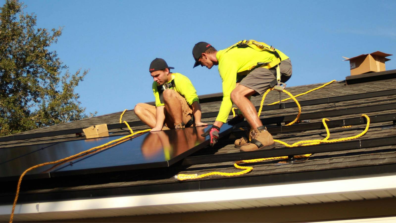 Technicians installing solar panels on a home's roof